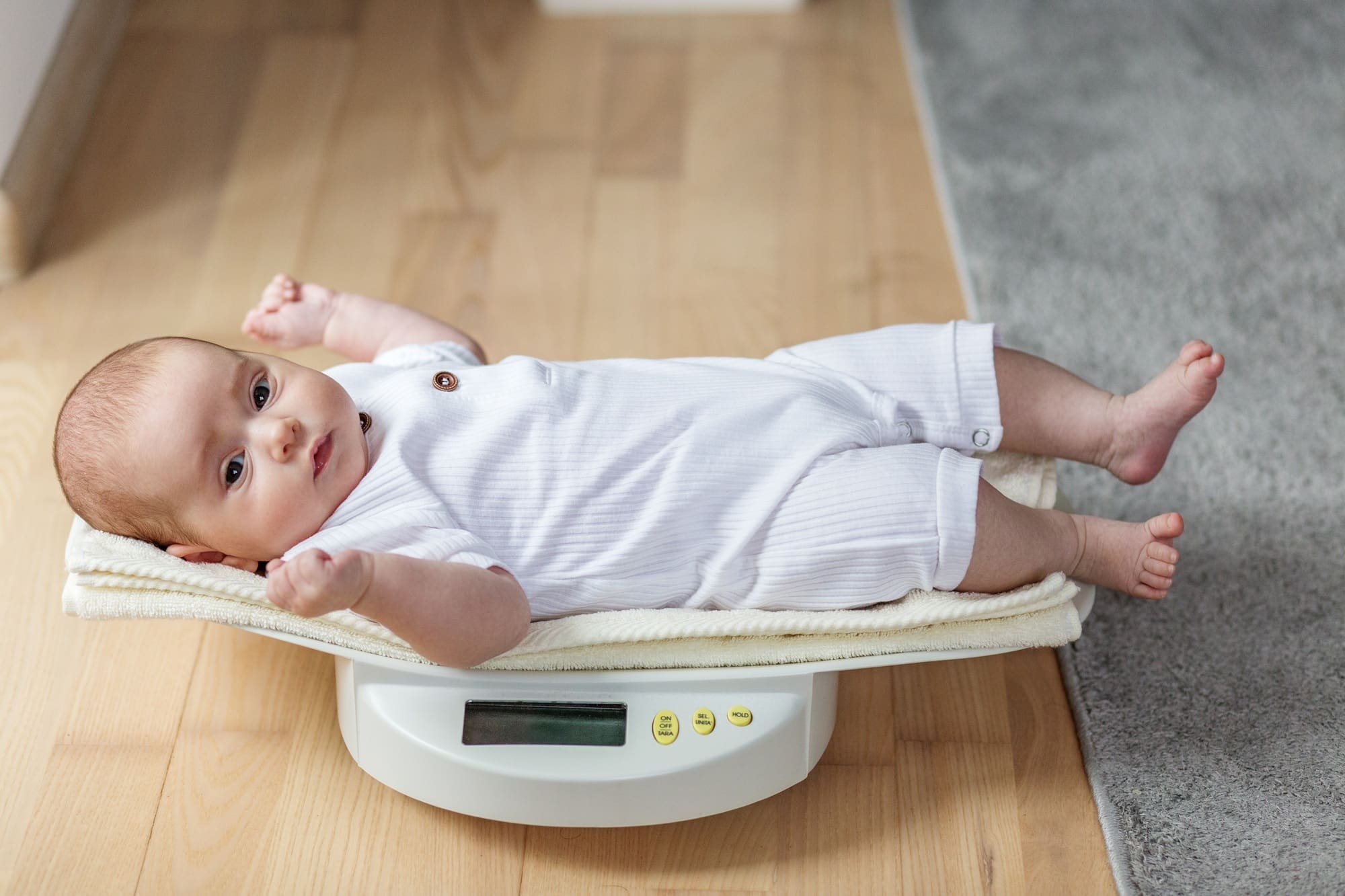 Newborn baby lying on digital scale